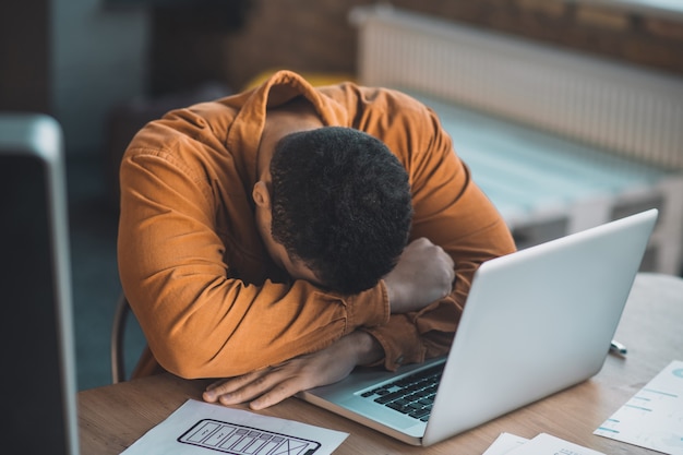 Bon à L'homme Fatigué De Dormir Sur Son Ordinateur Portable Alors Qu'il était Assis à La Table Au Travail