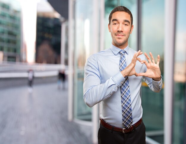 Bon jeune homme d&#39;affaires avec un geste d&#39;amour