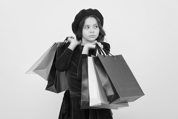 Bon shopping en ligne grande vente dans un centre commercial Anniversaire et cadeaux de Noël Journée internationale des enfants petite fille avec des sacs à provisions Accro du shopping