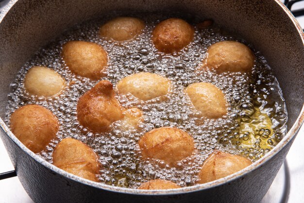 Bonbon brésilien appelé bolinho de Chuva, frit dans une poêle avec de l'huile, mise au point sélective.