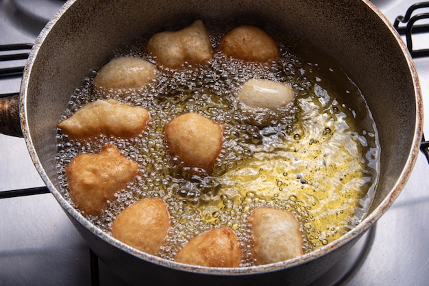 Bonbon brésilien appelé bolinho de Chuva, frit dans une poêle avec de l'huile, mise au point sélective.