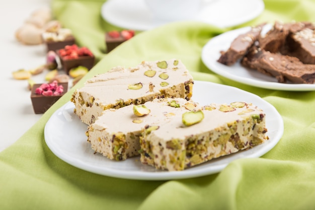 Bonbons arabes traditionnels halva de sésame avec du chocolat et de la pistache et une tasse de café. vue de côté