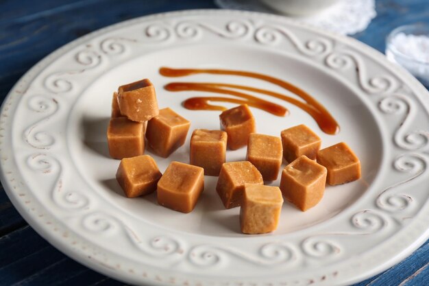 Bonbons au caramel sucré avec sauce sur gros plan de plaque