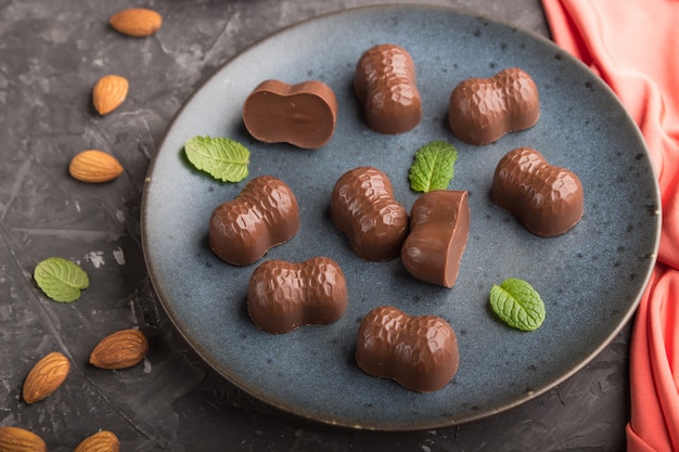 Photo bonbons au chocolat aux amandes sur fond de béton noir