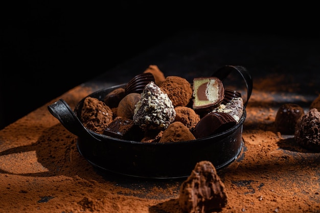 Bonbons au chocolat dans une assiette sur un fond sombre Cacao