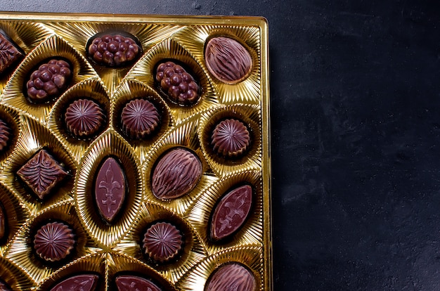 Bonbons au chocolat dans une boîte sur un fond sombre