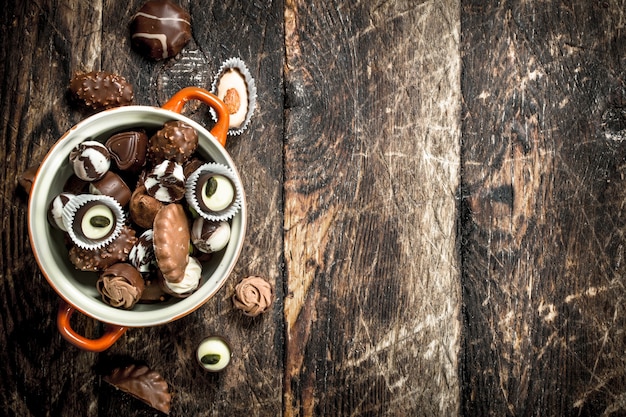 Bonbons au chocolat dans un bol. Sur un fond en bois.