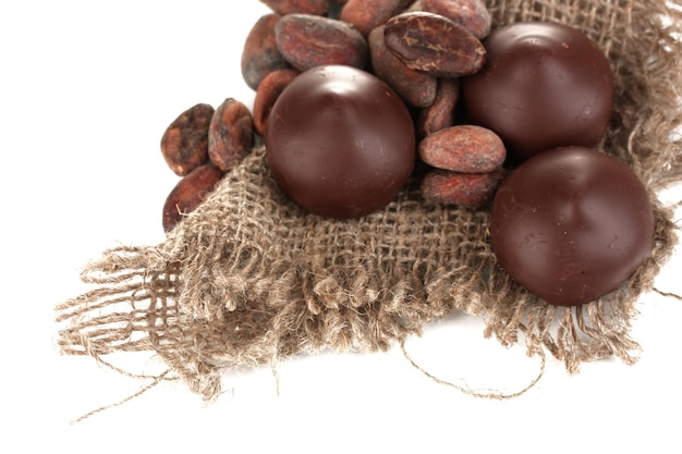 Bonbons au chocolat et fèves de cacao isolés sur blanc