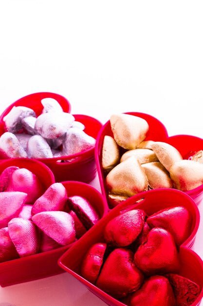 Bonbons au chocolat en forme de coeur enveloppés dans du papier d'aluminium coloré pour la Saint-Valentin.