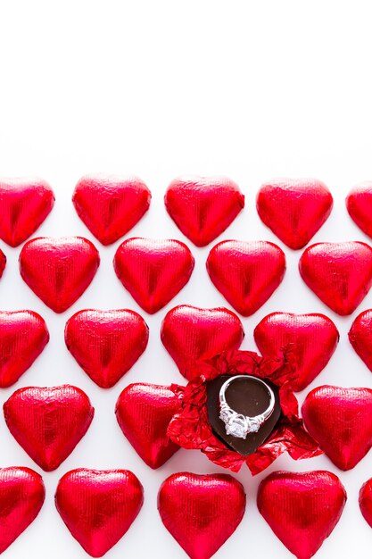Bonbons au chocolat en forme de coeur enveloppés dans du papier d'aluminium rouge pour la Saint-Valentin.