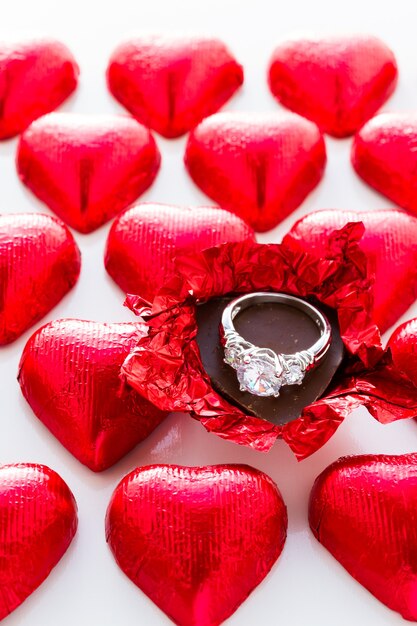 Bonbons au chocolat en forme de coeur enveloppés dans du papier d'aluminium rouge pour la Saint-Valentin.