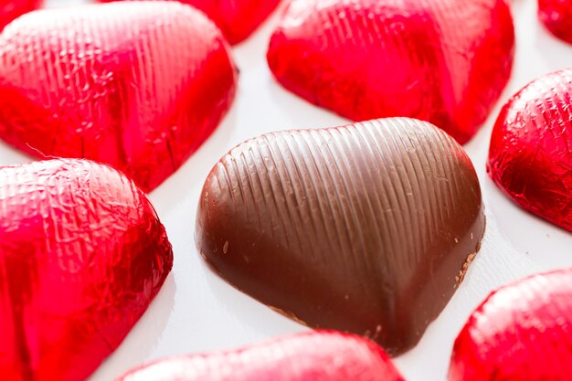 Bonbons au chocolat en forme de coeur enveloppés dans du papier d'aluminium rouge pour la Saint-Valentin.