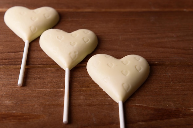 Bonbons au chocolat en forme de coeurs sur fond de bois