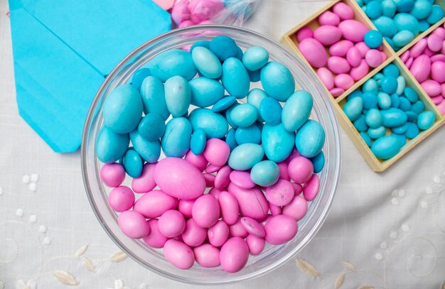 Bonbons bleus et roses dans un bol en verre fond blanc isolé c'est un garçon ou une fille sexe révèlent