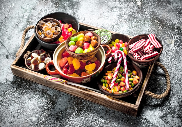 bonbons bonbons, fruits confits à la guimauve et gelée sur un plateau en bois.