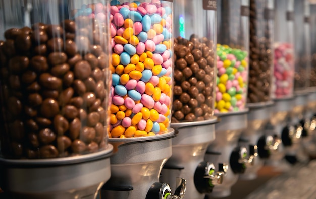 Bonbons brillants dans des conteneurs en poids dans un magasin de bonbons