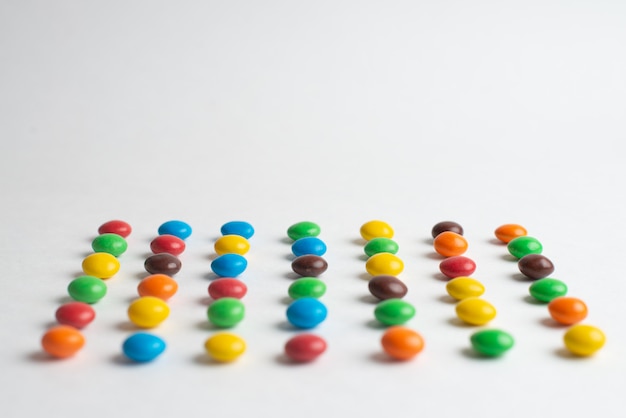 Bonbons de chocolat colorés sur fond blanc