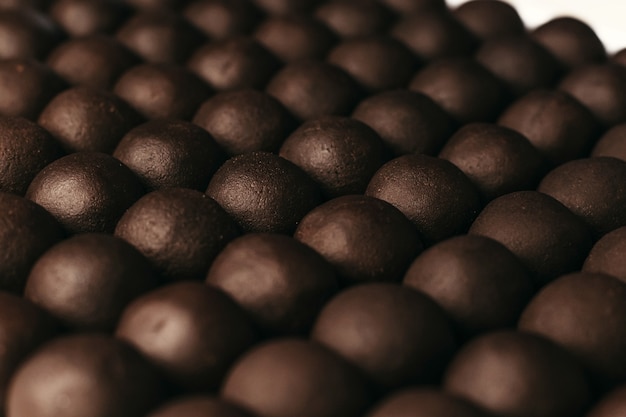 Bonbons de chocolats ronds. Fond sombre, dessert de luxe, chocolat noir, fait à la main.