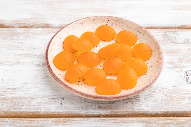 Bonbons à la citrouille gelée sur fond de bois blanc