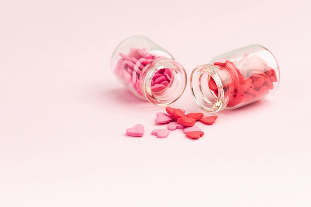 Bonbons - coeurs dans de petites bouteilles en verre. Bonbons colorés en forme de coeur Saint Valentin avec espace de copie. Sainte Valentine, cartes de voeux de fête des mères, invitation.