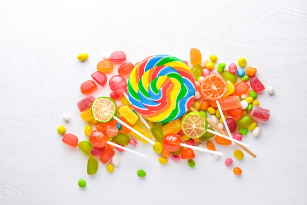 Bonbons colorés bonbons et sucettes Sur un fond en bois blanc Vue de dessus Espace libre