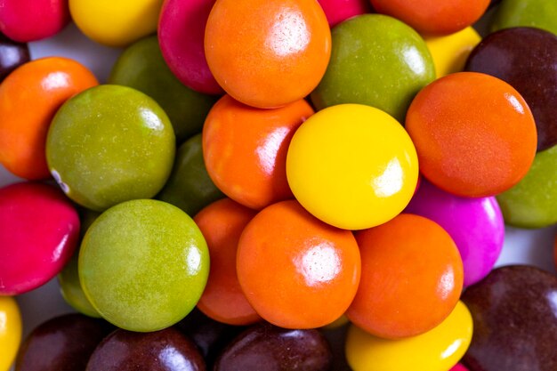 Des bonbons colorés ou des bonbons vue de haut d'une pile de bonbons avec un remplissage de chocolat en gros plan