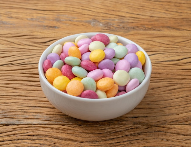 Bonbons colorés dans un bol sur une table en bois