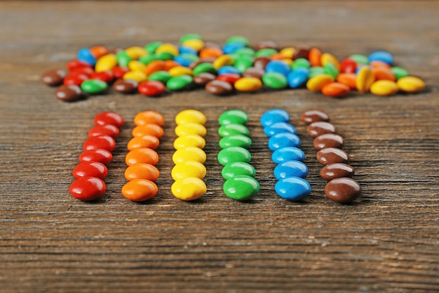 Bonbons colorés savoureux sur table en bois