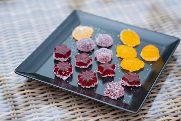 Bonbons de confiture de fruits et de baies, bonbons à la gelée sur une plaque noire.