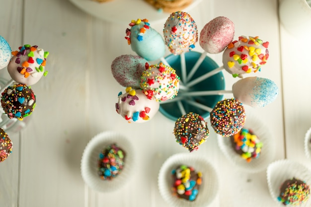 Bonbons décorés et cake pops sur planches de bois