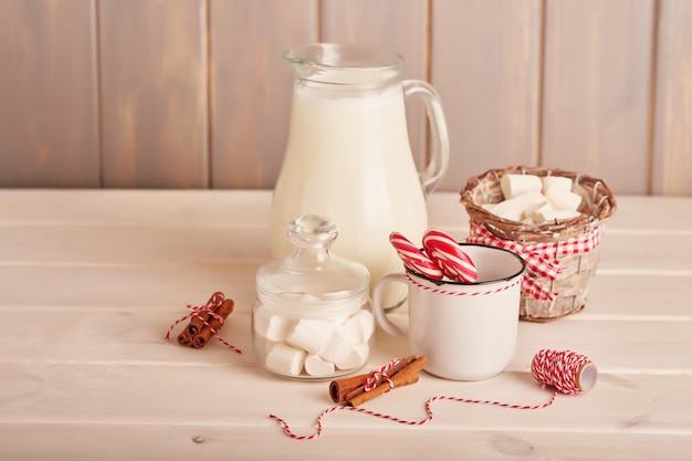 Bonbons du Nouvel An guimauves, sucettes et lait sur la table avec des cadeaux