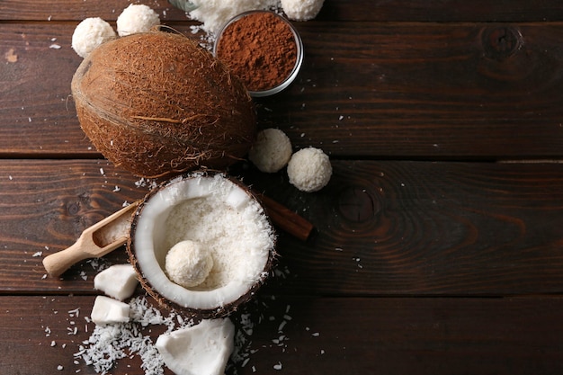 Bonbons en flocons de noix de coco et ingrédients sur fond de bois foncé