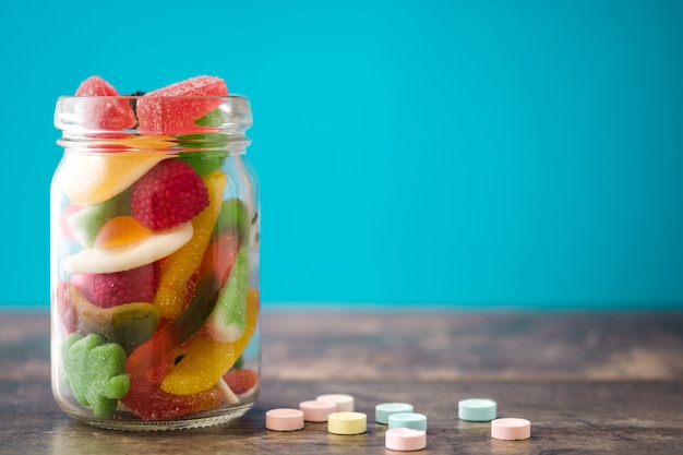 Bonbons et friandises pour enfants colorés en pot sur la table en bois