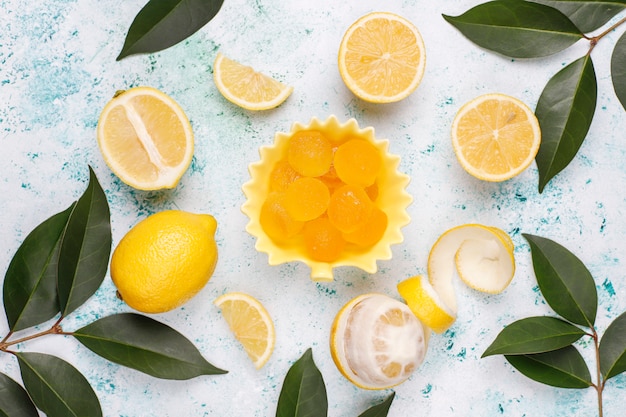 Bonbons de gelée de citron avec des citrons frais sur du béton, vue de dessus