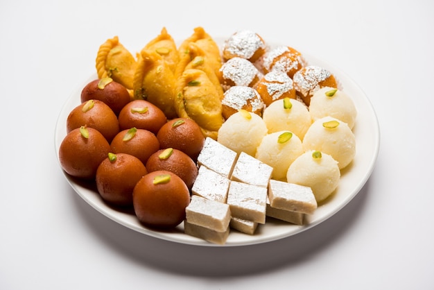 Les bonbons indiens dans une assiette comprennent Gulab Jamun, Rasgulla, kaju katli, morichoor ou Bundi Laddu, Gujiya ou Karanji pour la célébration de diwali