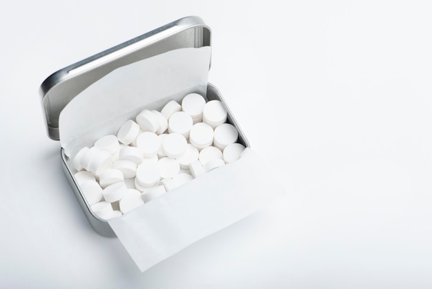 Bonbons à la menthe sur fond blanc Bonbons à la menthe blanche dans une boîte en fer blanc ouverte haleine fraîche ou mauvaise haleine...