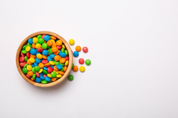 Des bonbons multicolores dans un bol sur un fond coloré concept d'anniversaire et de fête Vue supérieure avec espace de copie