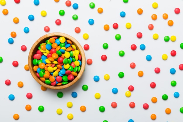 Bonbons multicolores dans un bol sur fond coloré concept d'anniversaire et de vacances Vue de dessus avec espace de copie