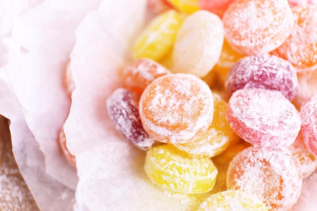 Bonbons multicolores sucrés sur papier gros plan