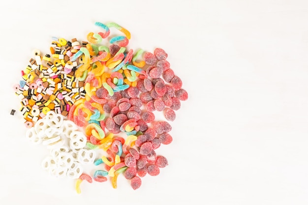 Bonbons multicolores sur un tableau blanc.