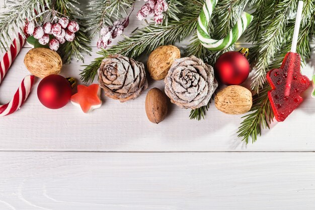 Bonbons de Noël et branches de sapin avec pommes de pin