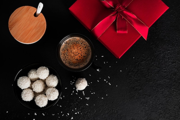 Bonbons à la noix de coco aux noix sur fond sombre Raffaello sur fond noir Photo de haute qualité