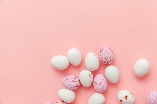 Bonbons de Pâques bonbons oeufs en chocolat isolés sur table rose