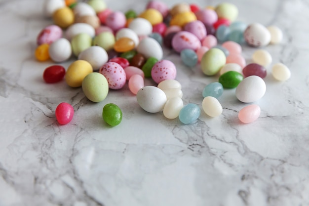 Bonbons de Pâques oeufs en chocolat et bonbons jellybean sur table en marbre gris à la mode