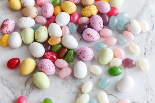 Bonbons de Pâques oeufs en chocolat et bonbons jellybean sur table en marbre gris à la mode