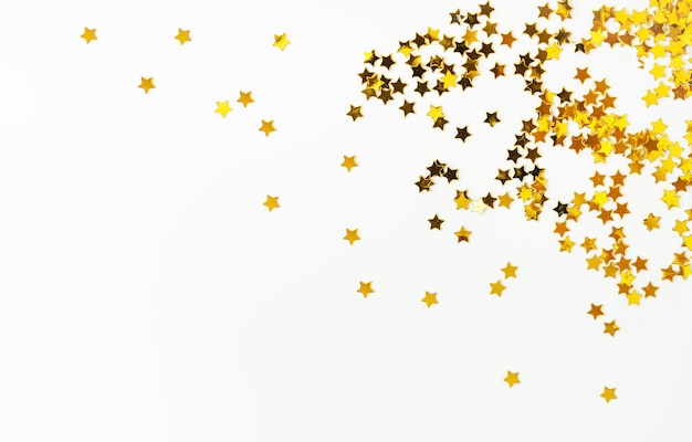 Photo des bonbons avec une petite étoile dorée éparpillée sur un fond blanc concentré sur le côté droit il y a une place pour une inscription