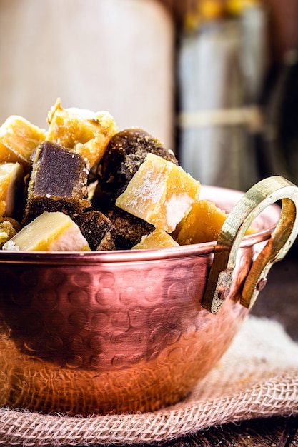 bonbons rapadura en morceaux dans un pot en cuivre, bonbons à base de canne à sucre ou mélasse de canne à sucre