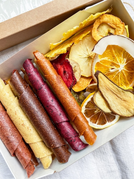 Photo bonbons sains en cuir de fruits et chips de fruits. pastille sucrée aux fruits purs en rouleaux