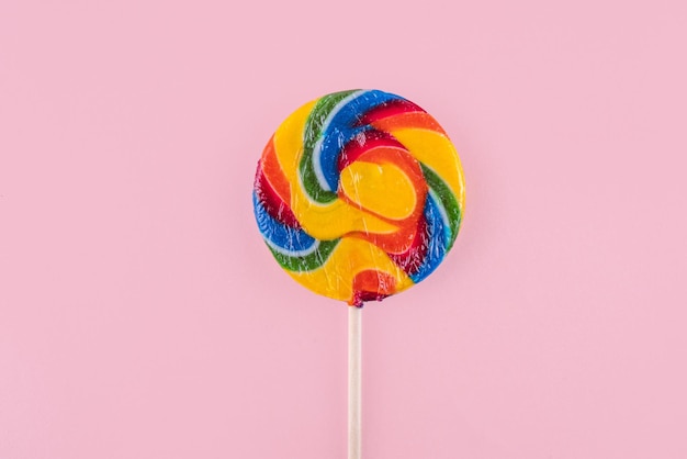 Photo des bonbons à la sucette à l'arc-en-ciel multicolore sur un bâton