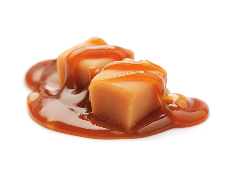 Photo bonbons sucrés avec garniture au caramel sur fond blanc.